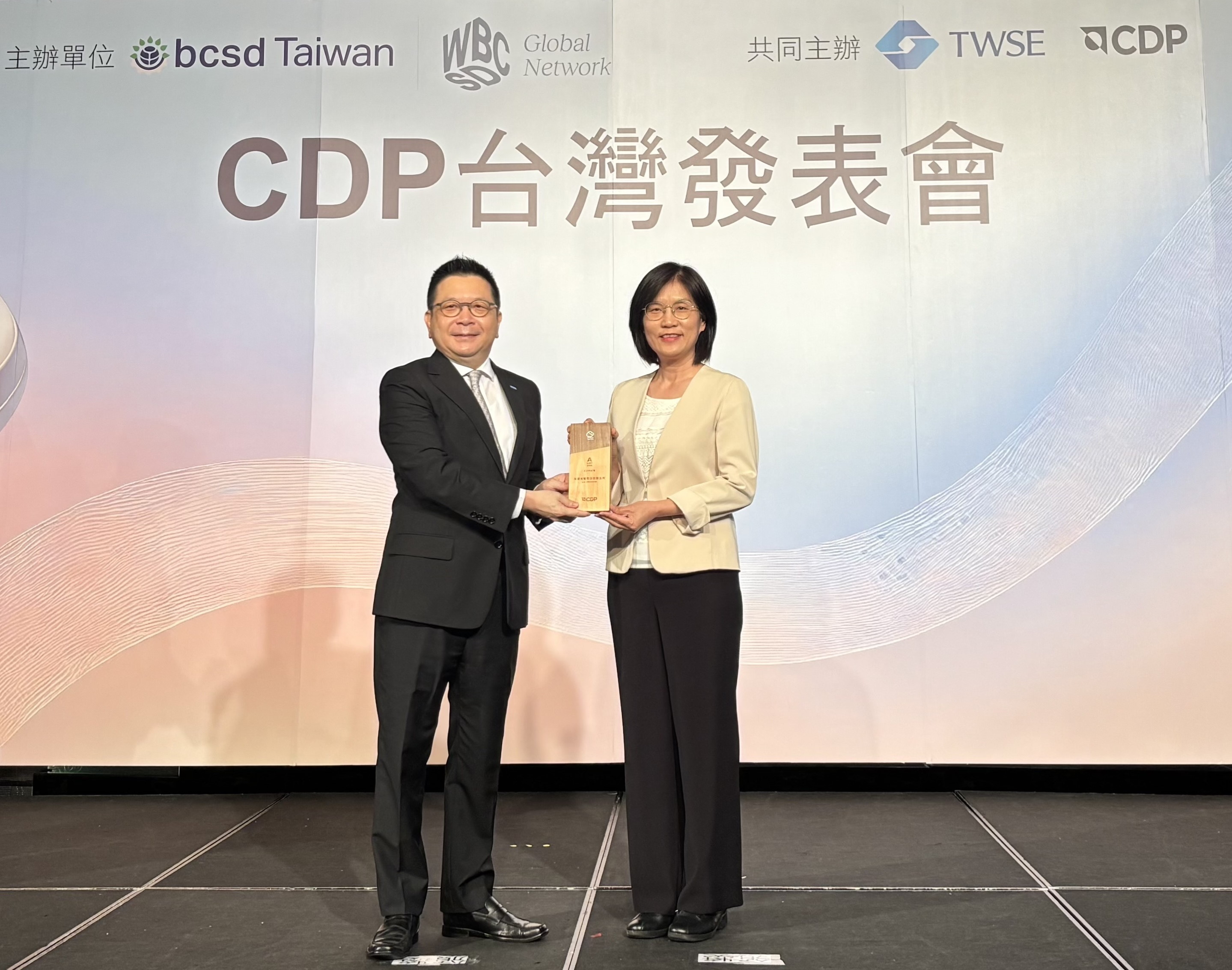 友達永續成果再獲國際評比肯定，獲頒CDP氣候與水資源雙項領導力評級。今由臺灣證券交易所董事長林修銘（左）頒獎，友達光電永續長古秀華（右）代表受獎